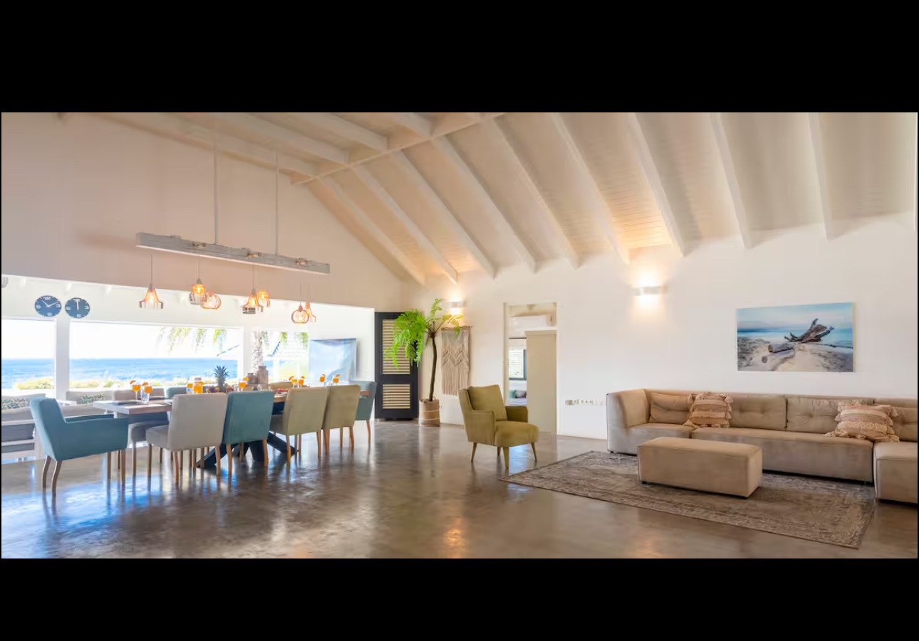 Vaulted living and dining room with a wide Caribbean Sea view
