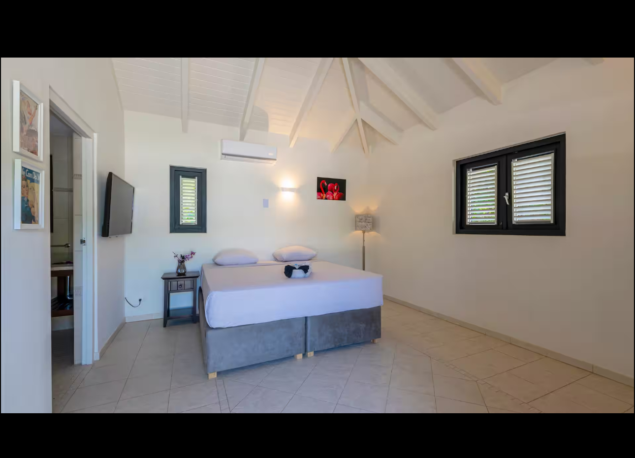 Vaulted bedroom with a king bed and private bathroom